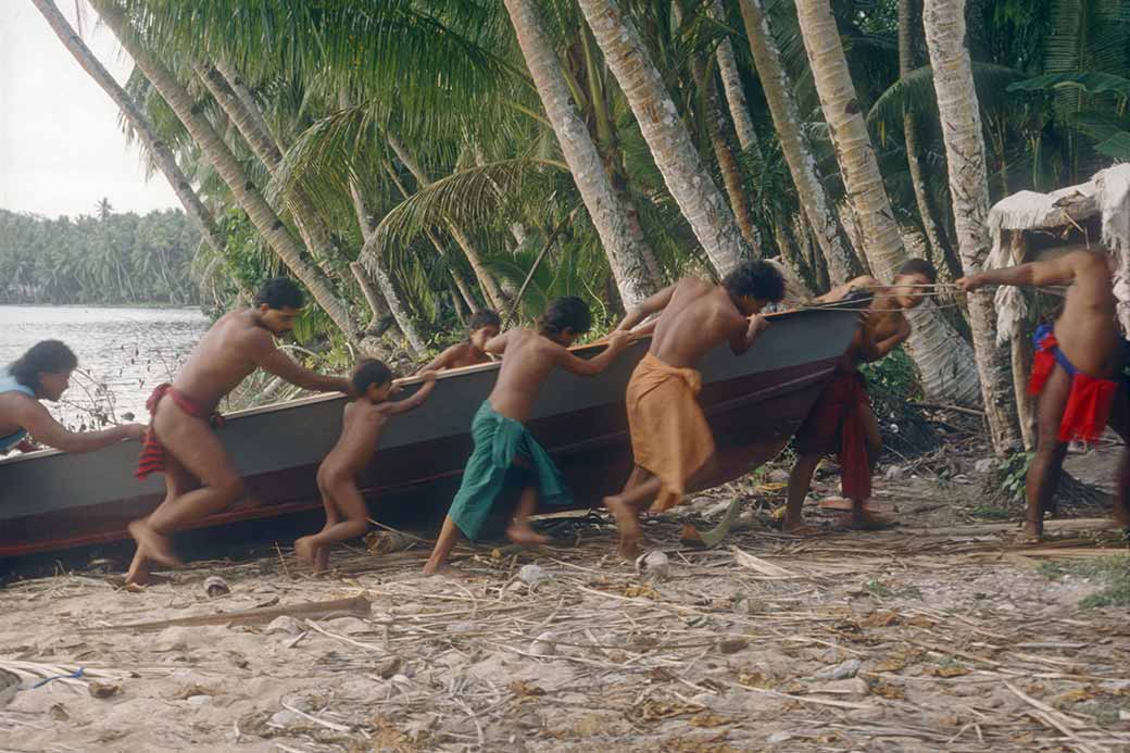 Dragging a canoe onto the beach